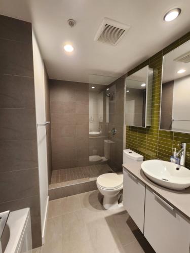 a bathroom with a toilet and a sink and a shower at Luxury Downtown Vancouver Suite in Vancouver