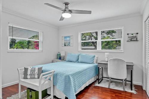 a bedroom with a bed and a desk and a chair at Oasis: Hot tub, fire pit, fun! in Vero Beach