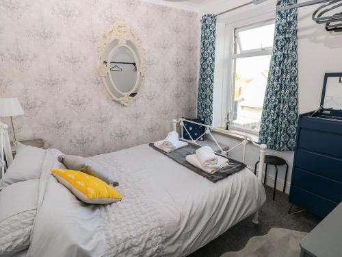 een slaapkamer met een bed met een spiegel en een raam bij 5 Pontardulais Road in Llanelli