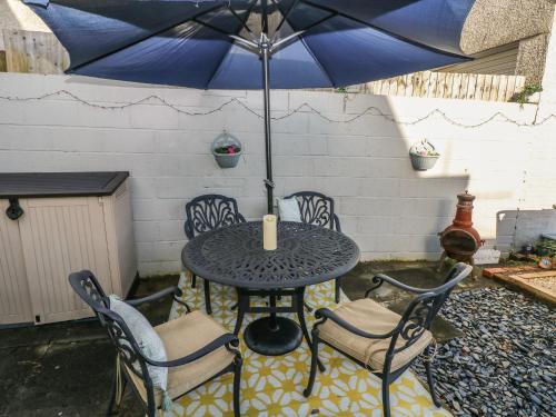 a table with chairs and an umbrella on a patio at 5 Pontardulais Road in Llanelli