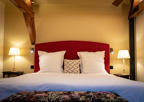 a bedroom with a large bed with a red headboard at CLOS DU BAILLI in Saint-Omer