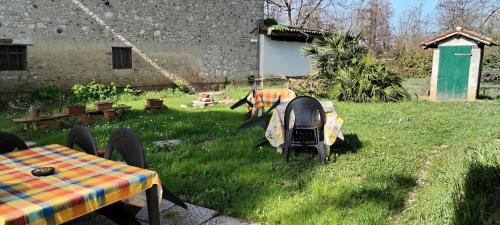 a garden with a table and chairs in the grass at Stasion Di Pueste in Nogaredo Al Torre