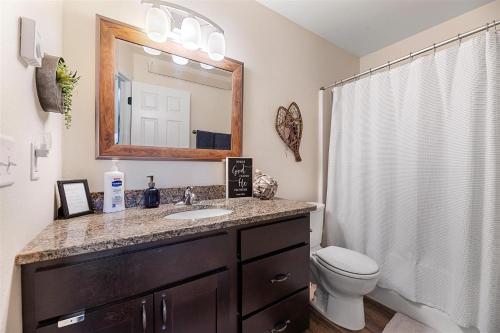 ein Badezimmer mit einem Waschbecken, einem WC und einem Spiegel in der Unterkunft 35 3rd street Upper Townhome in Lead
