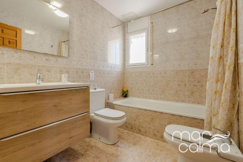 a bathroom with a toilet and a tub and a sink at Villa Dolce Relax by MarCalma in Les tres Cales
