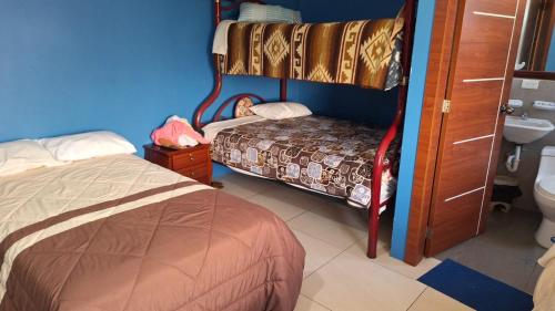 a bedroom with a bed and a sink and a toilet at Hostal y Complejo Turístico La Rueda in Guaranda
