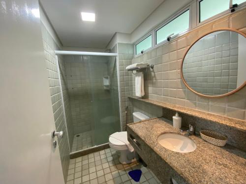 a bathroom with a sink and a mirror and a toilet at Ancorar Flat Resort in Porto De Galinhas
