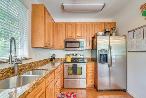 a kitchen with wooden cabinets and a stainless steel refrigerator at Decks, Docks and Kayaks Waterfront Homosassa Gem in Homosassa
