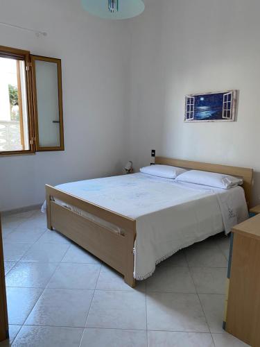 una camera da letto con un grande letto in una stanza bianca di Villa Mare Giuggiola ad Alcamo Marina