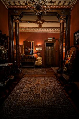 a hallway with a living room with a large rug at The Alamo Guest House in Glasgow