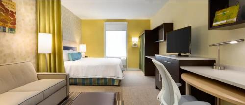 um quarto de hotel com uma cama e uma televisão em Home2 Suites by Hilton Houston Pasadena em Pasadena