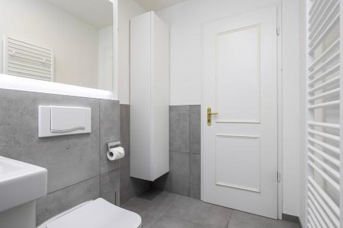 ein Bad mit einem WC und einer weißen Tür in der Unterkunft Modern, gemütlich, zentral & nahe KarLi in Leipzig