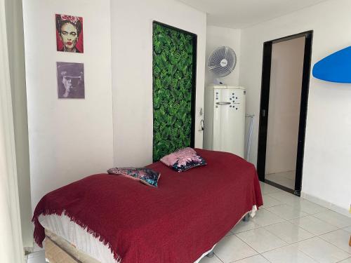 um quarto com uma cama com uma parede verde em Quarto e sala pé na areia em Guarapari