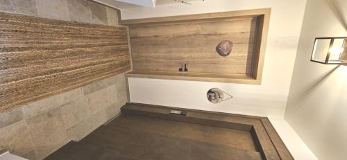 a bathroom with a wood paneled wall at Poppies Flats in Ypres
