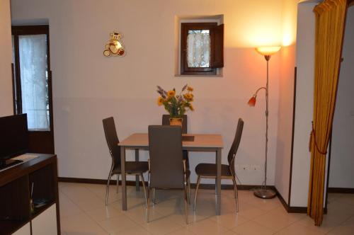 een eettafel met stoelen en een vaas met bloemen erop bij Magnolia - Large and comfortable studio flat in Florence