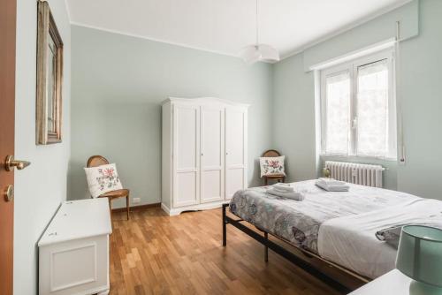 ローマにあるVatican Rome Apartmentの白いベッドルーム(ベッド1台、椅子2脚付)