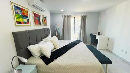 een slaapkamer met een groot bed met kussens erop bij Residences by MP Cabo San Lucas in Cabo San Lucas
