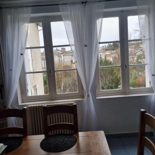 a room with two large windows with white curtains at Chez Jack Confolens in Confolens