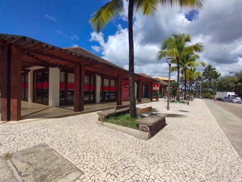 a building with palm trees in front of a street at Pousada Sonho da Lagoa in Praia do Forte