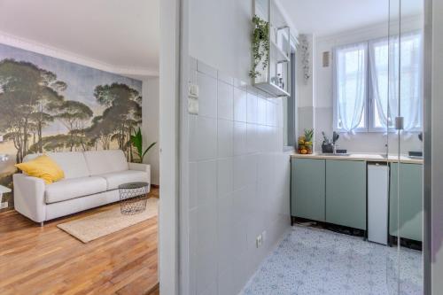 巴黎的住宿－Le studio d'Alésia，一间带白色沙发的客厅和一间厨房