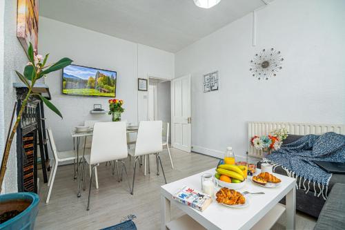 a living room with a table with food on it at Stylish Apartment Near Broadway Theatre in Catford