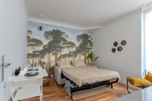 巴黎的住宿－Le studio d'Alésia，卧室配有一张床,墙上挂有绘画作品