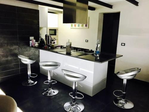 a kitchen with two stools and a counter top at Moderno loft alle porte di Milano - 115mq - 3 posti in Cormano