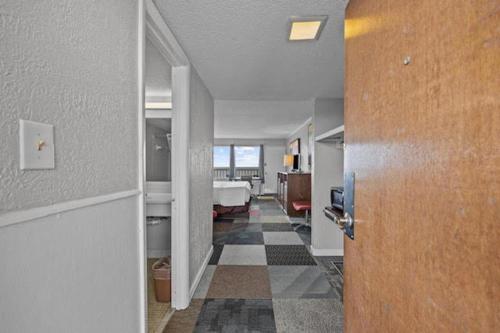 um corredor com um quarto com uma cama e uma porta em The Red Tree Inn em Myrtle Beach