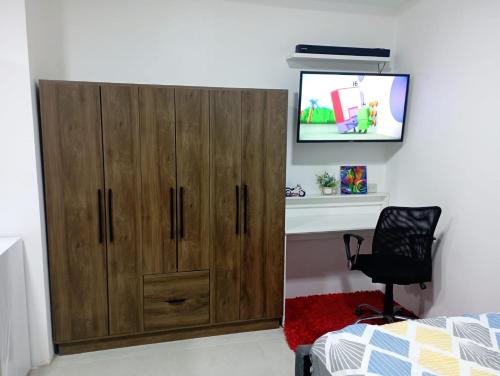 un gran armario de madera en un dormitorio con TV en Suite elegante en urbanización privada, en Machala