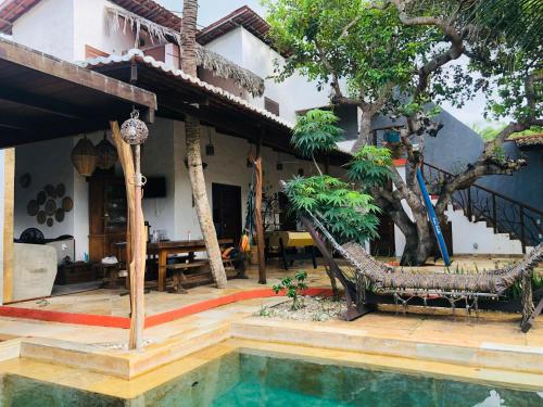 a house with a swimming pool in front of a house at Casa cajueiro PREA in Jericoacoara
