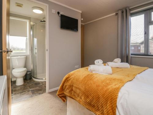 a bedroom with a bed with towels on it at Lakeside 20 in Carnforth