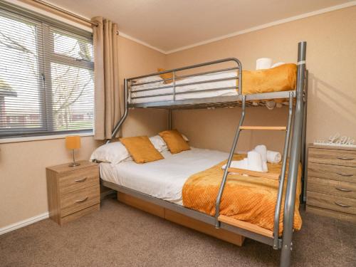 a bedroom with two bunk beds and a window at Lakeside 20 in Carnforth