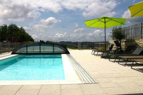 una piscina con 2 sombrillas y algunas sillas y mesas en Wiesen-Hof, 