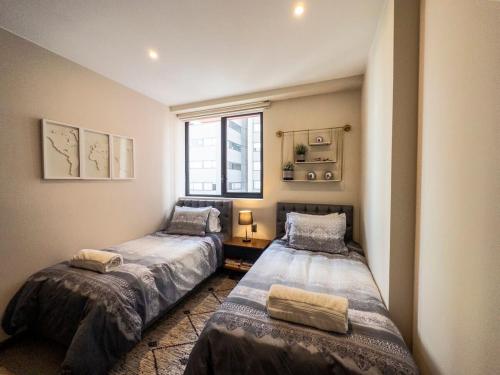 two beds in a small room with a window at Nuevo Dpt l Alberca + Padel l Soumaya 10 min in Mexico City