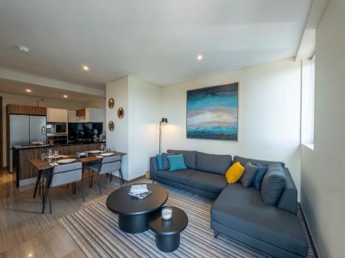 a living room with a blue couch and a kitchen at Nuevo Dpt l Alberca + Padel l Soumaya 10 min in Mexico City