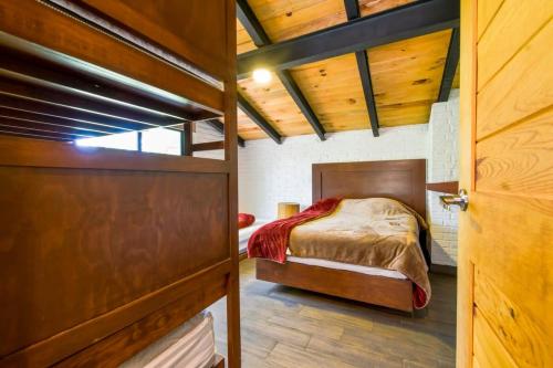 a bedroom with a bed and a wooden door at Hermosa cabaña de descanso en Tlapalpa in Tapalpa