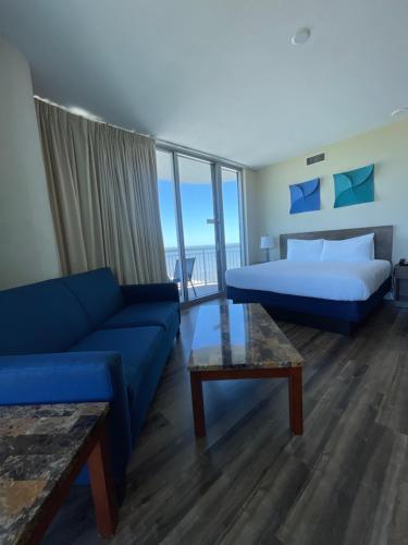 a hotel room with a bed and a couch and a bed at South Beach Biloxi Hotel & Suites in Biloxi