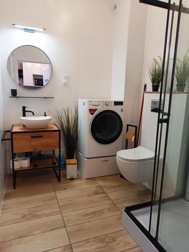 uma casa de banho com uma máquina de lavar roupa e um lavatório em Sleep In Apartament Centrum em Breslávia