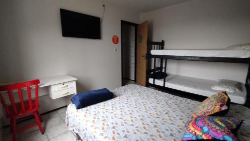 a bedroom with a bed and two bunk beds at Mandallah Hostel in Joinville