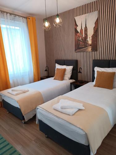 a hotel room with two beds and a window at Sleep In Apartament Centrum in Wrocław