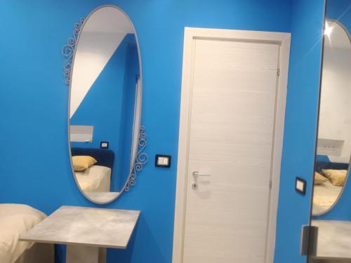 een kamer met een blauwe muur en een spiegel bij Pokój dla 2 z prywatnym balkonem, łazienką i wejściem in Bari