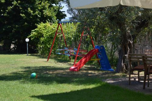 a playground with a slide and a swing at Nikos & Panagiota in Vourvourou