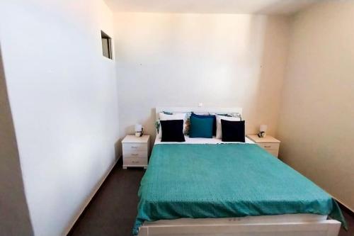 um quarto com uma cama com um edredão verde em Cozy Home with Stunning Views! em Ponta do Sol