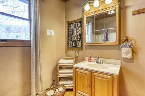 a bathroom with a sink and a mirror and a window at Cozy Black Hills Retreat in Lead