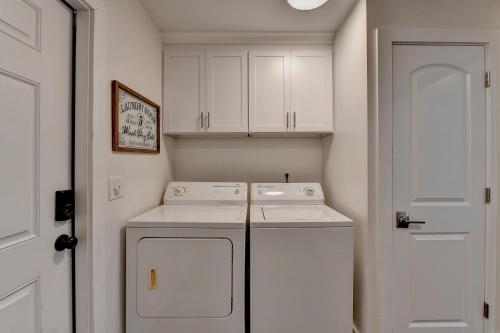 cocina con armarios blancos, lavadora y secadora en Dreamy 3bed/3bath home with Yard, en Atlanta