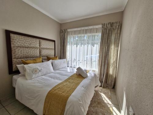 a bedroom with a large bed with a large window at Botle Hive in Kempton Park