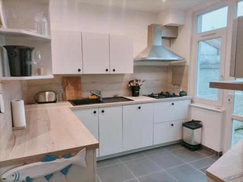 eine Küche mit weißen Schränken und einer Spüle in der Unterkunft Villa 300m de la plage in Le Touquet-Paris-Plage