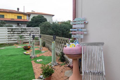 a garden with a sink and signs on the side of a house at la coccinella in Marina di Pisa
