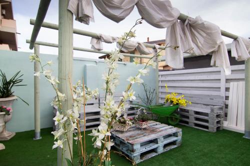 a porch with a bench and flowers on it at la coccinella in Marina di Pisa