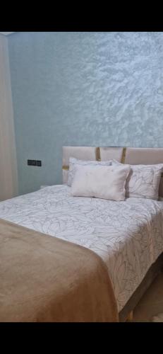 a bed with white sheets and pillows in a bedroom at Appartement Marjana in Meknès