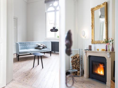 uma sala de estar com um sofá azul e uma lareira em B&B Pastorie Balegem em Balegem